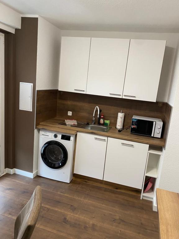 a kitchen with a washing machine and a microwave at FeWo Wieko Plauen H1 3 OG links Family Appartement XL in Plauen