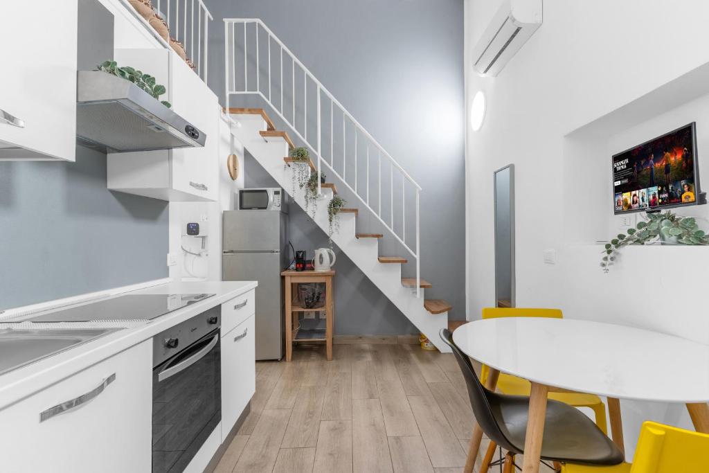 a kitchen with a table and a staircase at Design-M2 Moscova-Centrale Fs-wifi-netflix in Milan