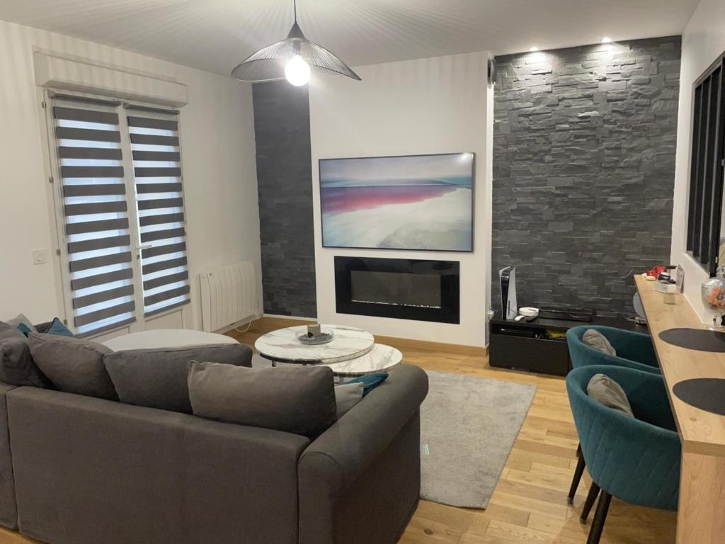 un salon avec un canapé et une télévision dans l'établissement Maison moderne proche CDG, à Aulnay-sous-Bois