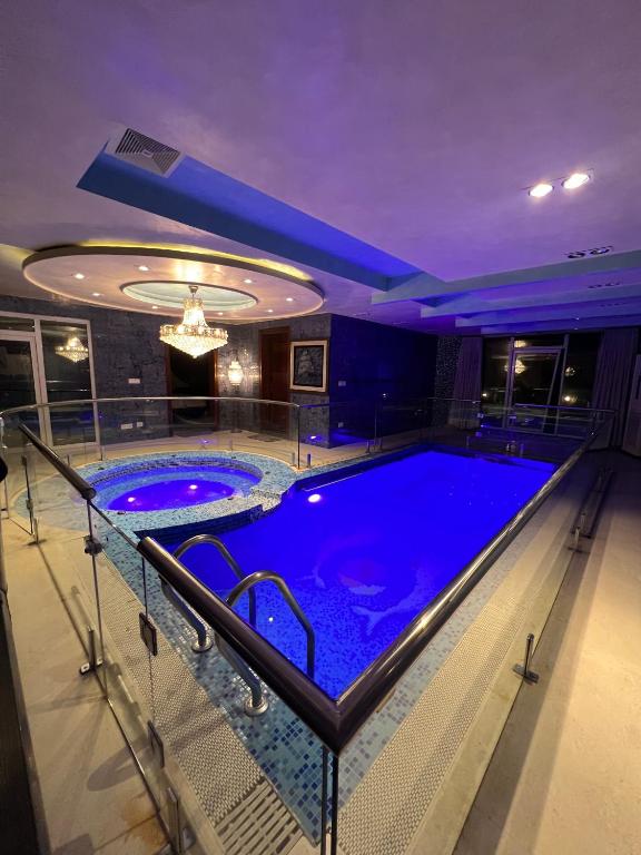 a large swimming pool in a building with a purple ceiling at Avenue-3 Guest House in Islamabad
