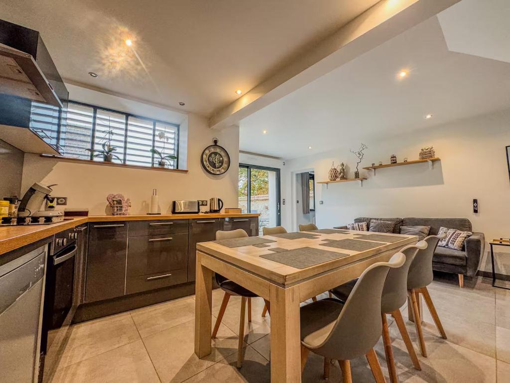 une cuisine et un salon avec une table et des chaises dans l'établissement Maison charmante et moderne près de Chartres, à Sours