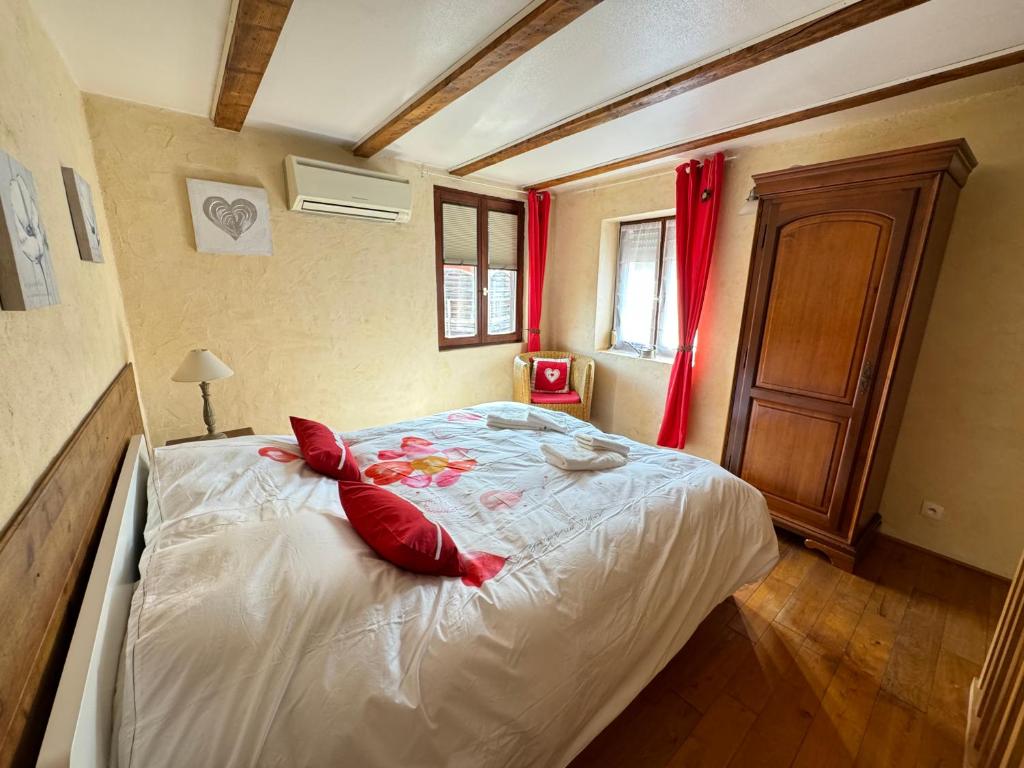 - une chambre avec un lit doté d'oreillers rouges dans l'établissement L'Évasion Alsaciene, à Wintzenheim