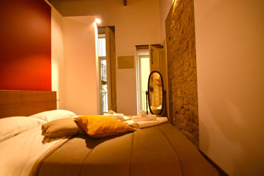 a bedroom with a bed with a mirror on it at La Casa di Apollo in Naples