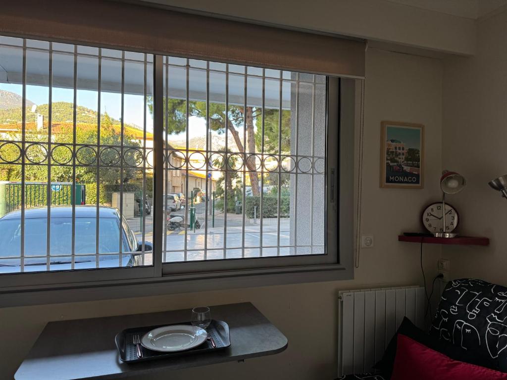 - une fenêtre dans une chambre avec vue sur une voiture dans l'établissement Joli STUDIO Bord de Mer entre Menton et Monaco, à Roquebrune-Cap-Martin