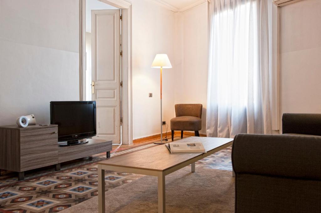 a living room with a couch and a tv at MH Apartments Tetuan in Barcelona
