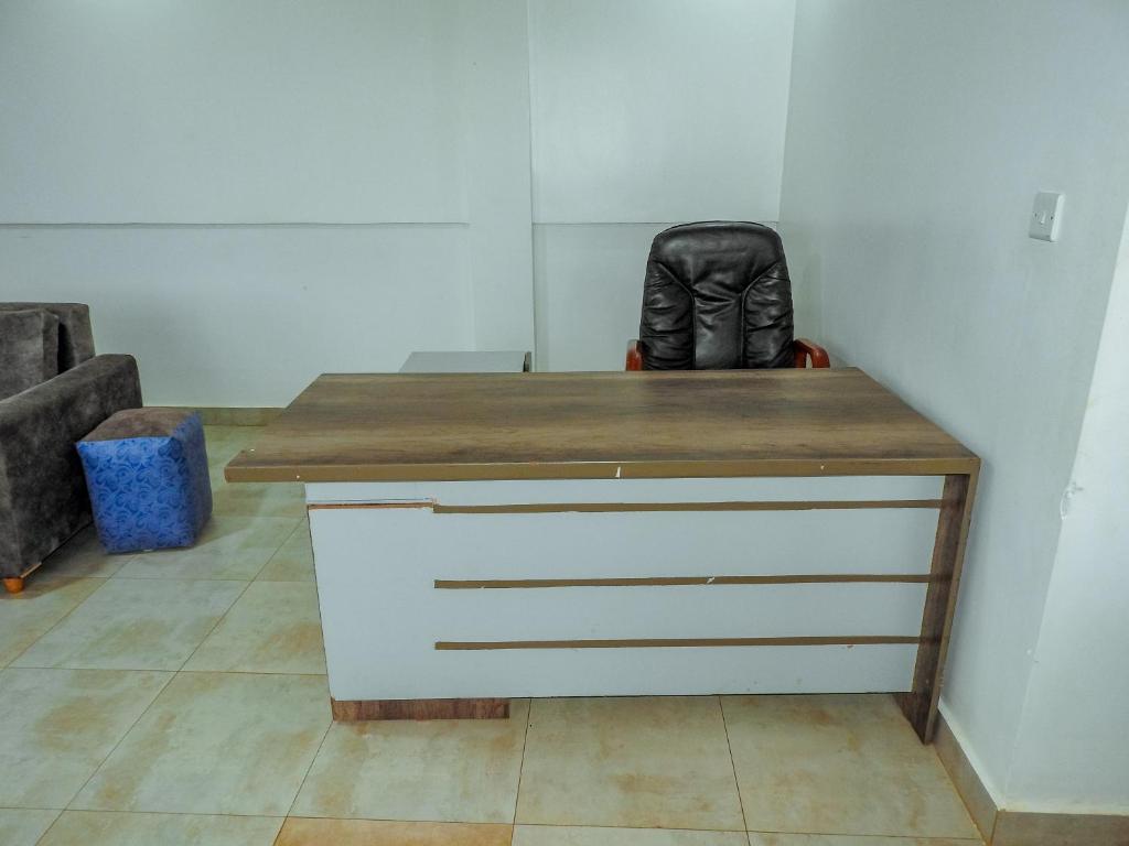 una scrivania in una stanza con una sedia in pelle di 5 Stones a Kigali