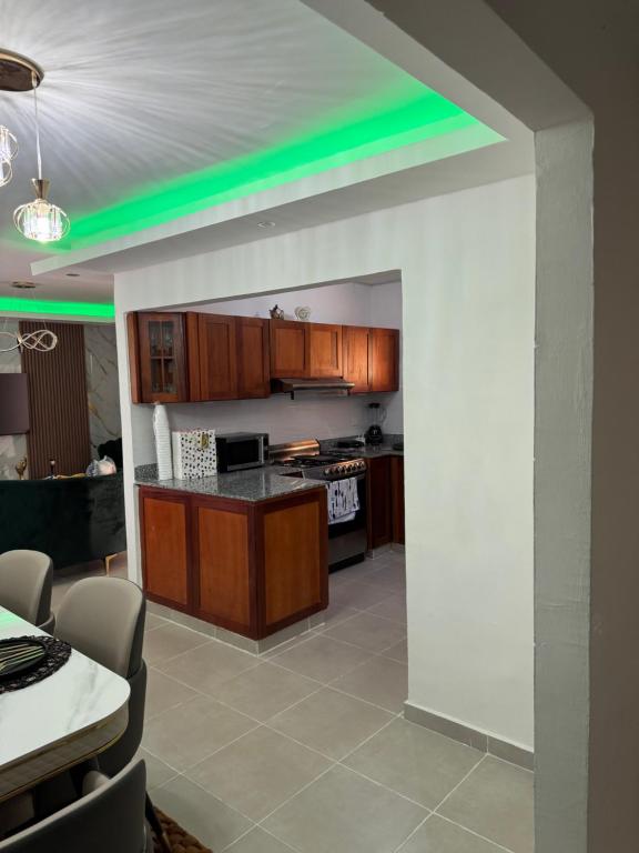 a kitchen with a green light on the ceiling at Modern and Cozy 3-Bedroom Apartment in Santo Domingo in Los Paredones