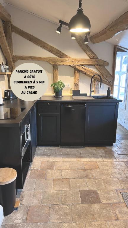 - une cuisine avec des placards noirs et un évier dans l'établissement La tour de l Horloge, appt typique à 500m du château, à Chinon