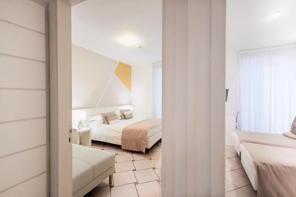 a hotel room with two beds and a mirror at Hotel Rivage in Sorrento