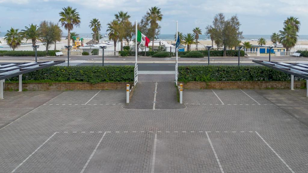 a parking lot with two flags in a parking lot at Hotel Du Soleil in Rimini