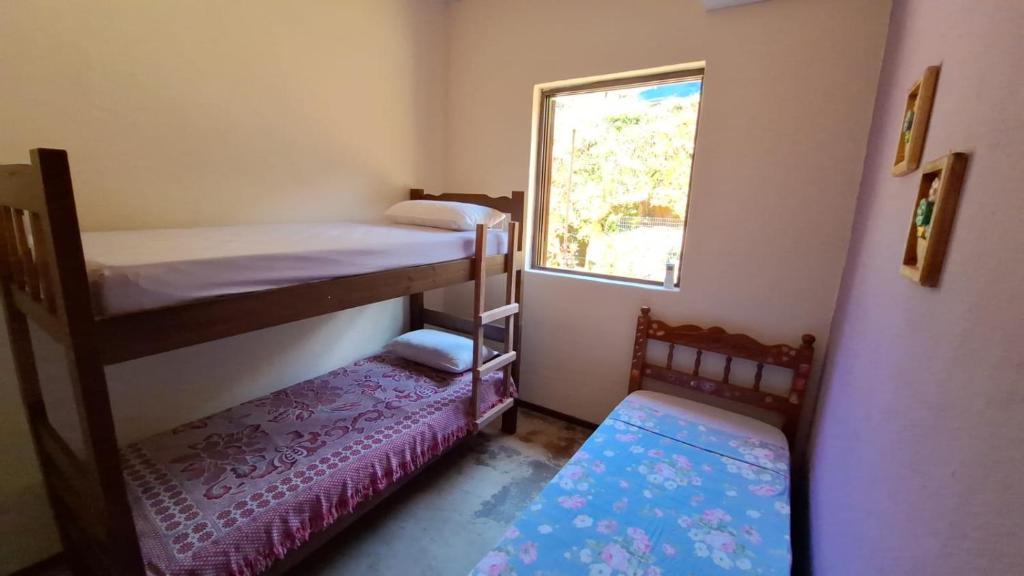 une petite chambre avec deux lits superposés et une fenêtre dans l'établissement Casa de campo Sanloá, à Parati
