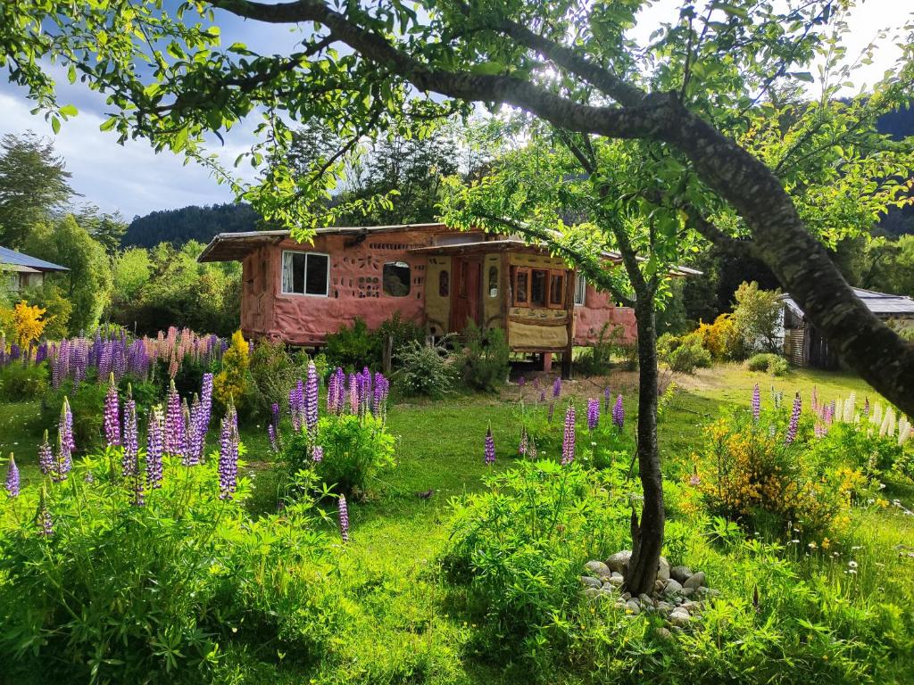 a garden with purple flowers in front of a cabin at Rey Sol Reina Luna in Lago Puelo