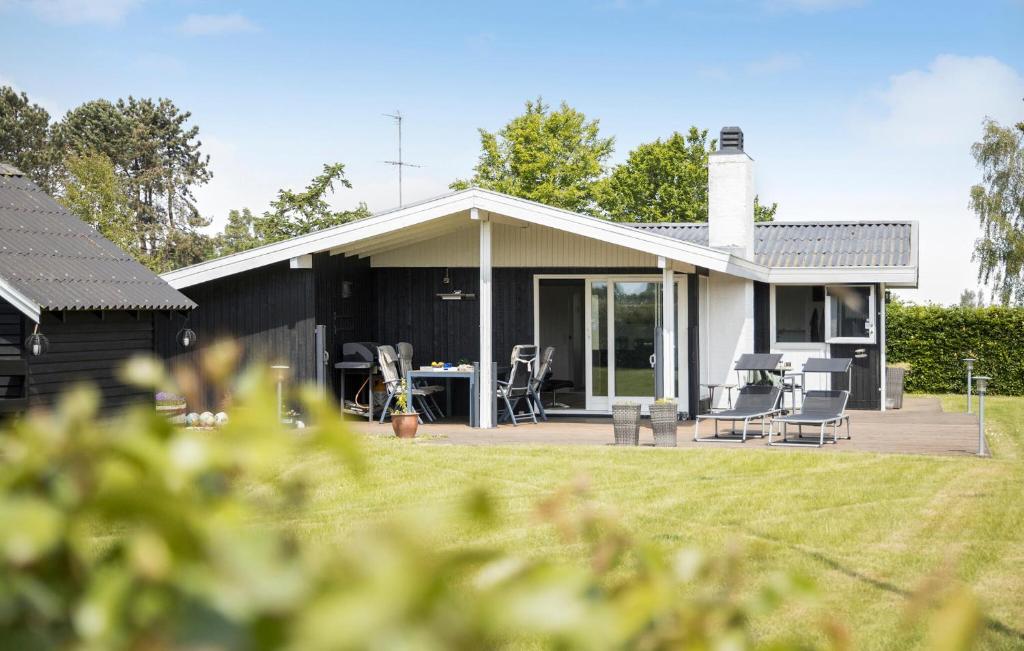 a house with a patio and a table and chairs at 3 Bedroom Lovely Home In Otterup in Otterup