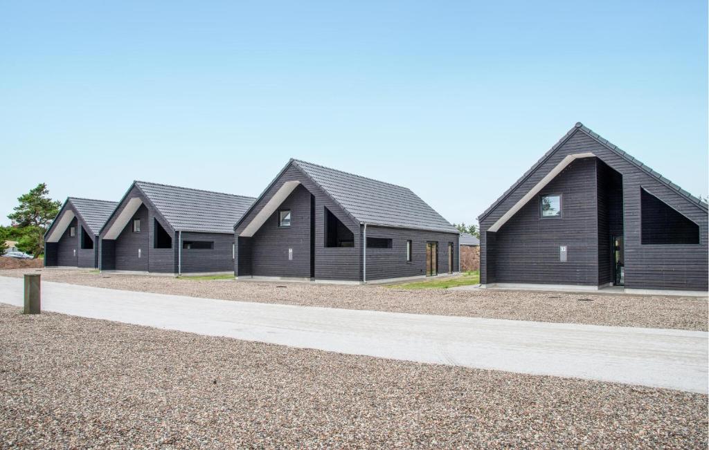 a row of homes with black roofs on a road at Nice Home In Rømø With Wifi in Kongsmark
