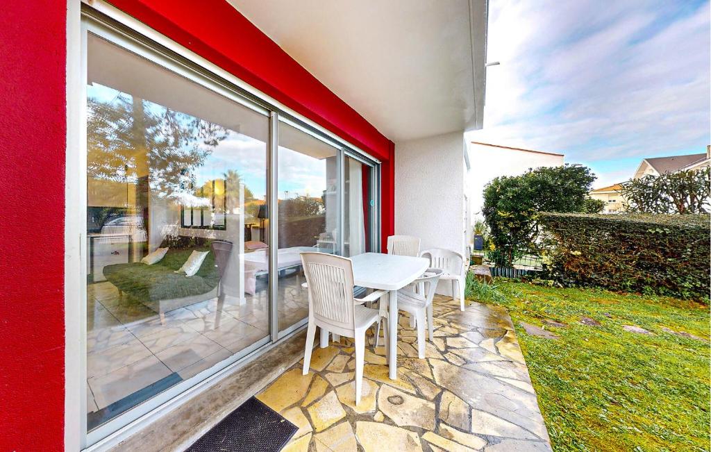 eine Terrasse mit einem weißen Tisch und Stühlen auf dem Balkon in der Unterkunft Pet Friendly Apartment in Saint-Georges-de-Didonne