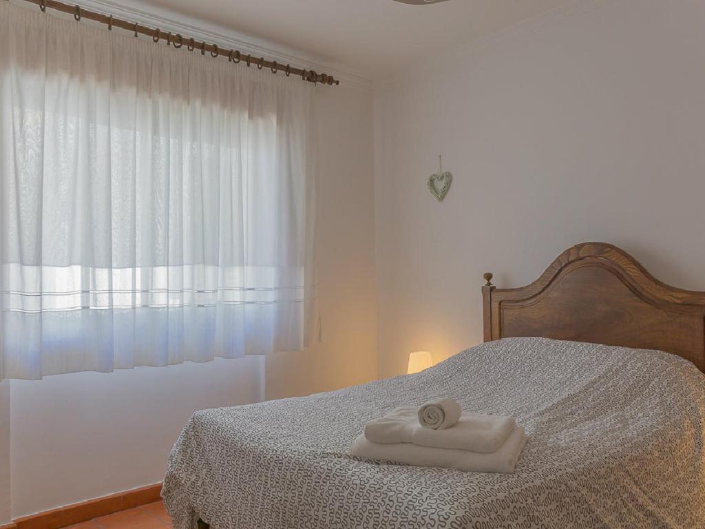 阿爾布費拉的住宿－Bravo Apartment，一间卧室配有一张带两条白色毛巾的床