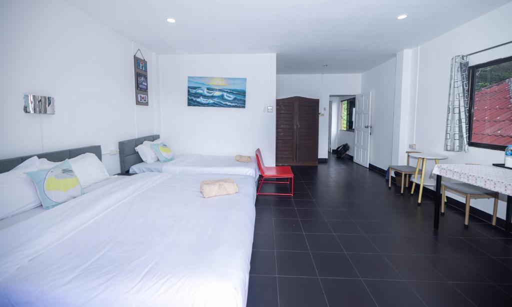 a bedroom with a large white bed and a table at Belle Cose Guest House Phuket in Patong Beach