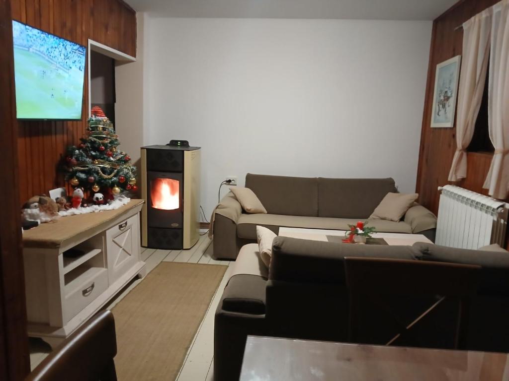 a living room with a christmas tree and a couch at Holiday Home Stevas in Žabljak