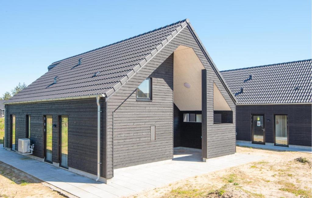 una casa con techo de gambrel en Cozy Home In Rømø With Wifi, en Kongsmark