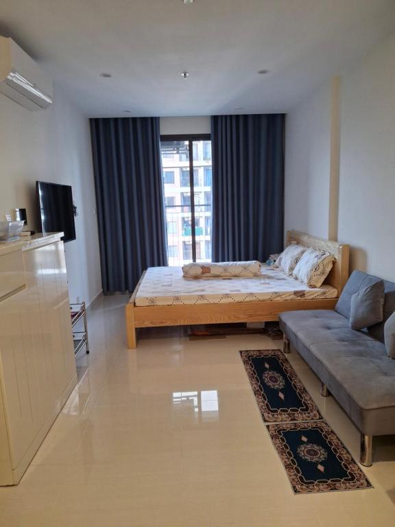 a living room with a bed and a couch at Vinhomes Grand Park in Long Bình
