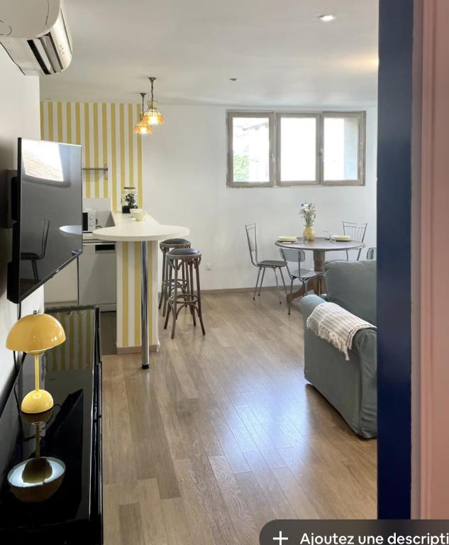 un salon avec un canapé, une table et des chaises dans l'établissement L'appartement d'Albert - french style, à Carcassonne