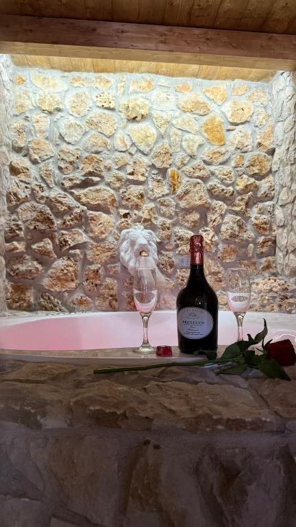 a bottle of wine and two glasses on a table at Gesualdo Suites in Gesualdo