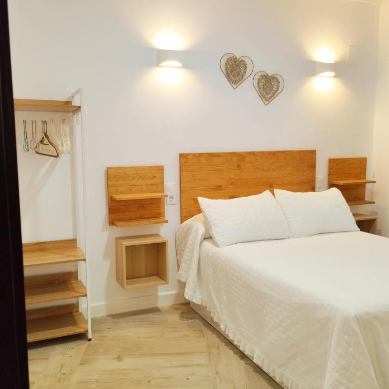a bedroom with a white bed and two hearts on the wall at APARTAMENTO SOL in Chipiona