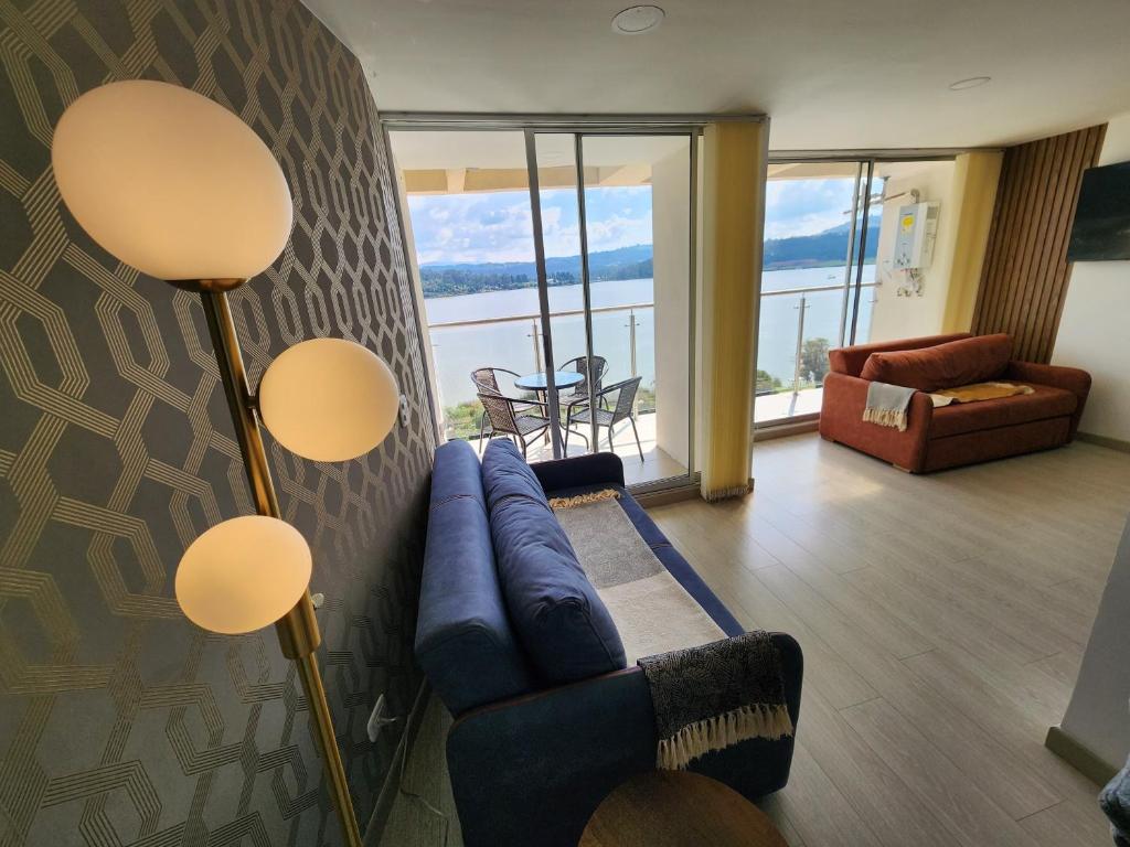 a living room with a couch and a view of the ocean at Increíble apartamento con vista panorámica al lago Sochagota in Paipa