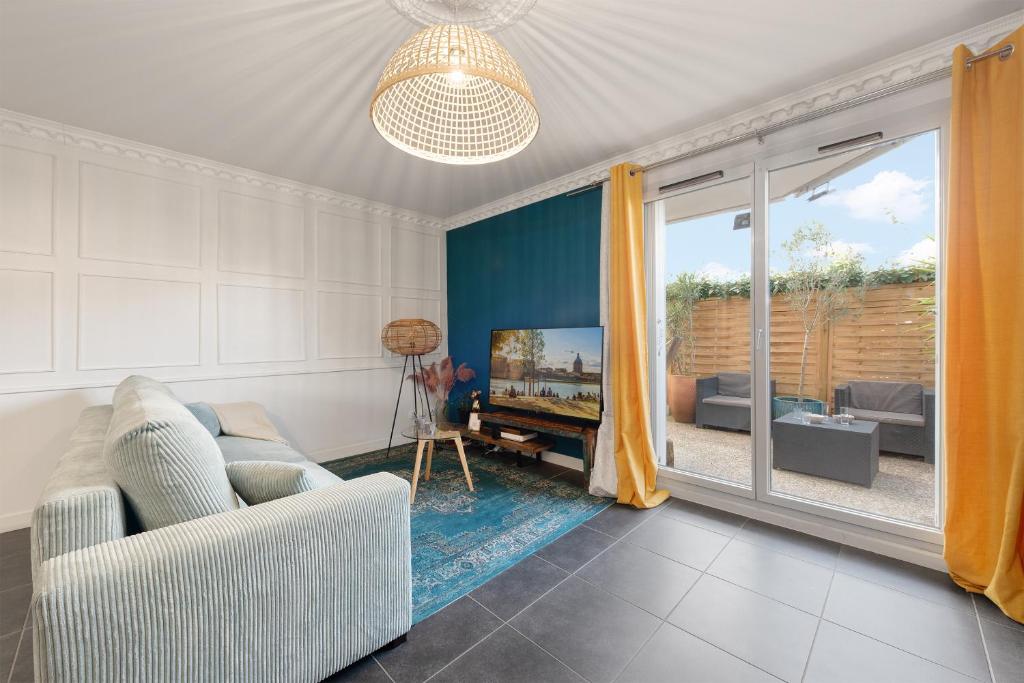 un salon avec un canapé et une télévision dans l'établissement T2 Havre de paix 1 à 4 p - Terrasse - parking - piscine - salle sport - tennis, à Toulouse