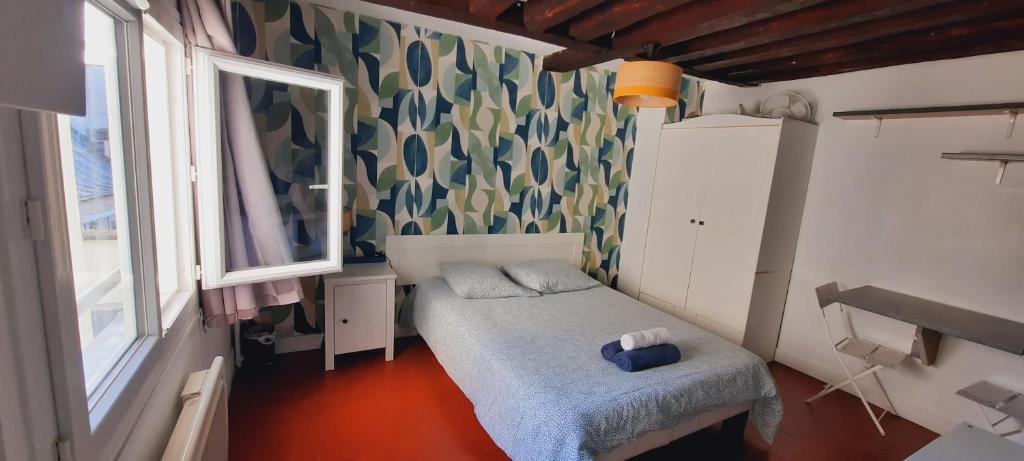 une petite pièce avec un lit et une fenêtre dans l'établissement Emplacement idéal les Halles, à Paris