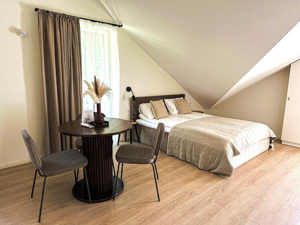 a bedroom with a bed and a table and chairs at Kurortas Apartments in Palanga