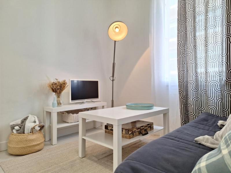 Il comprend un salon doté d'un canapé et d'une table avec une télévision. dans l'établissement T2 Coeur de Ville - Casa Burot, à Rochefort