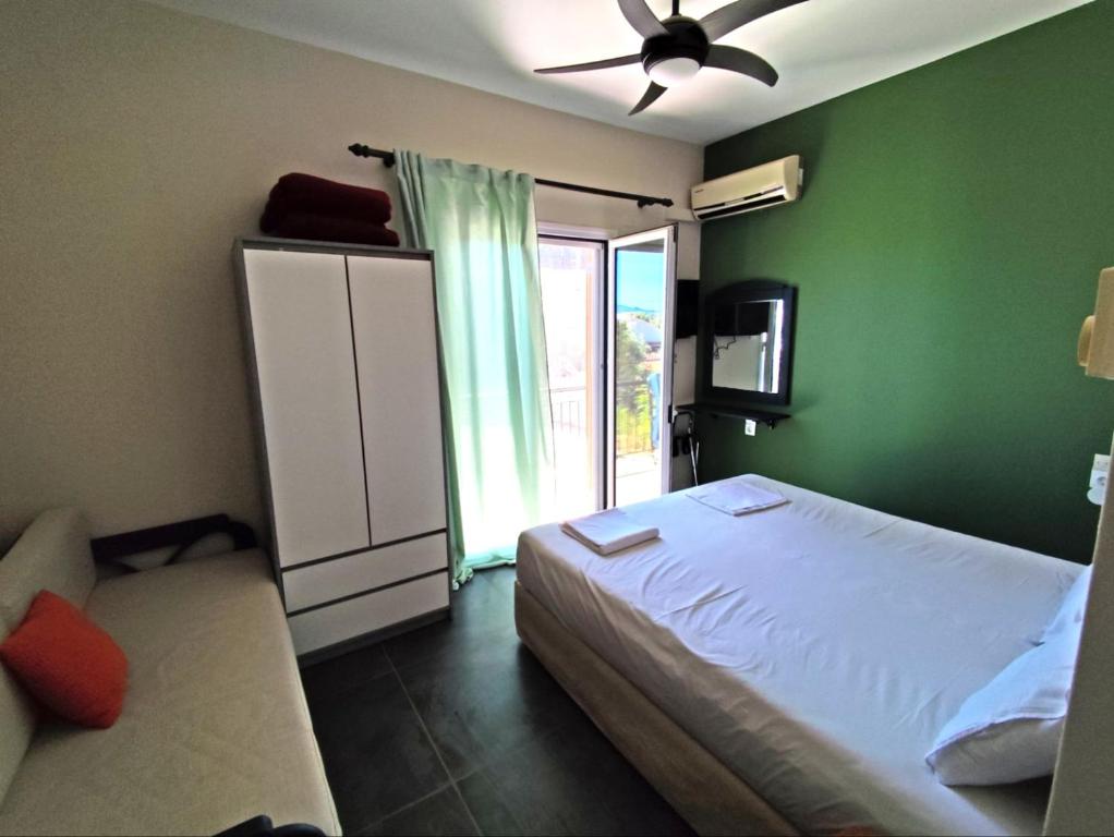 a bedroom with a bed and a green wall at Pool me up 22 apartment in Megali Ammos