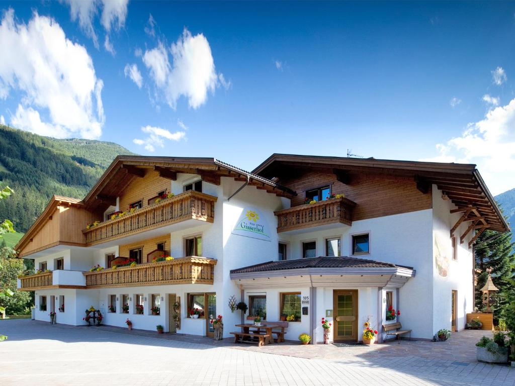 een groot wit gebouw met een balkon bij Hotel Gisserhof in San Giovanni in Val Aurina