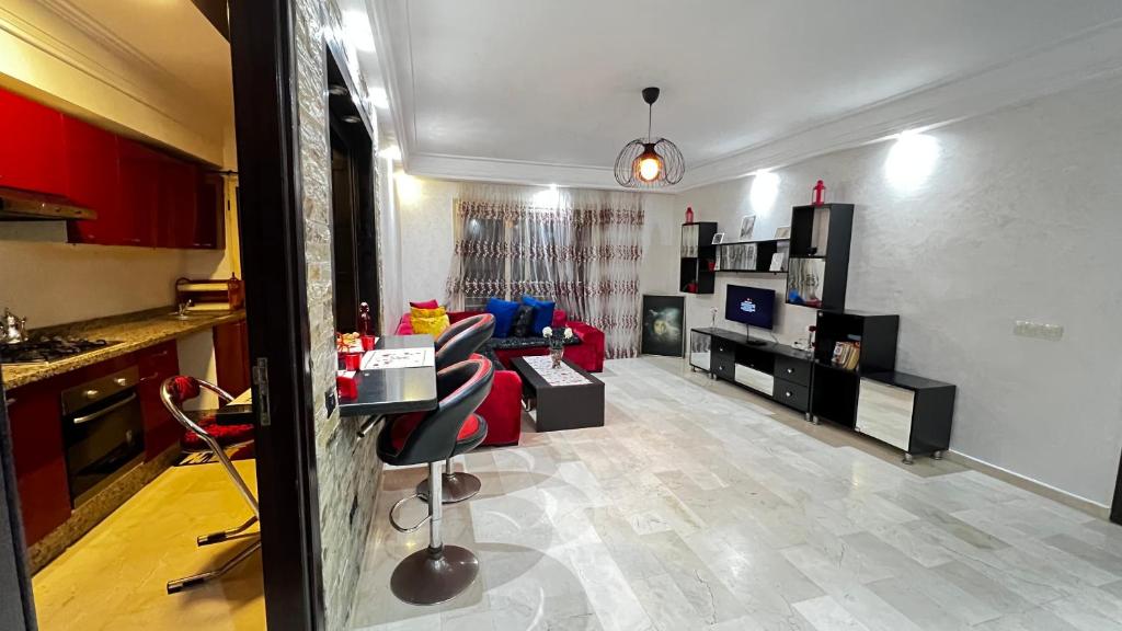 a living room with a red couch and a kitchen at Studio de luxe in Casablanca