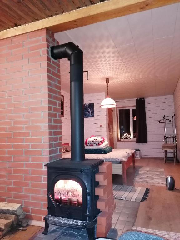 a brick fireplace in a living room with a bed at Sillavahi maja in Myza Igaste