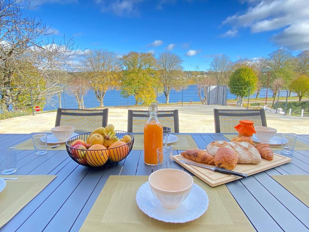 a table with food and a bowl of fruit and juice at Villa le Menhir 4 Ch au Bord du Lac et Terrasse in Villefranche-de-Panat