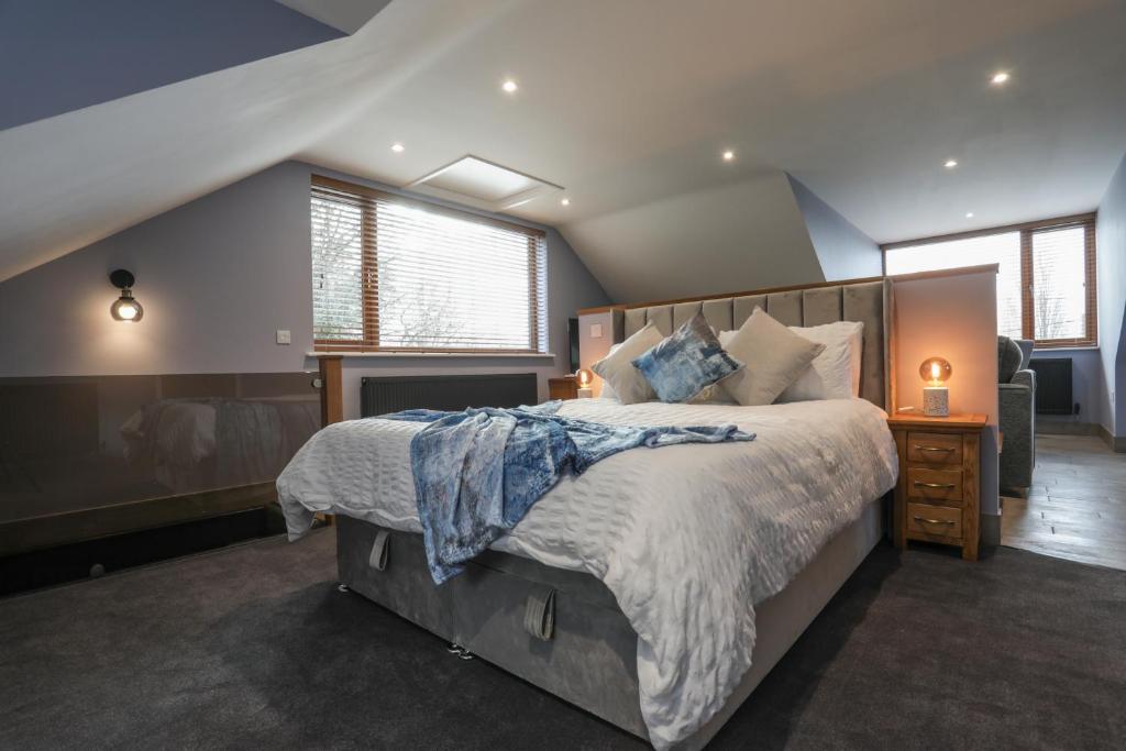 a bedroom with a large bed and some windows at Oak View Lodge - Deluxe Master Studio near Ipswich & Woodbridge in Playford