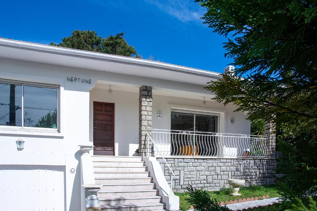 une maison blanche avec une terrasse couverte et des escaliers dans l'établissement Villa Spacieuse avec Piscine Privée, à Biarritz