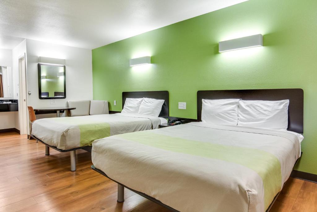 two beds in a room with green walls at Motel 6-Longview, TX - North in Longview