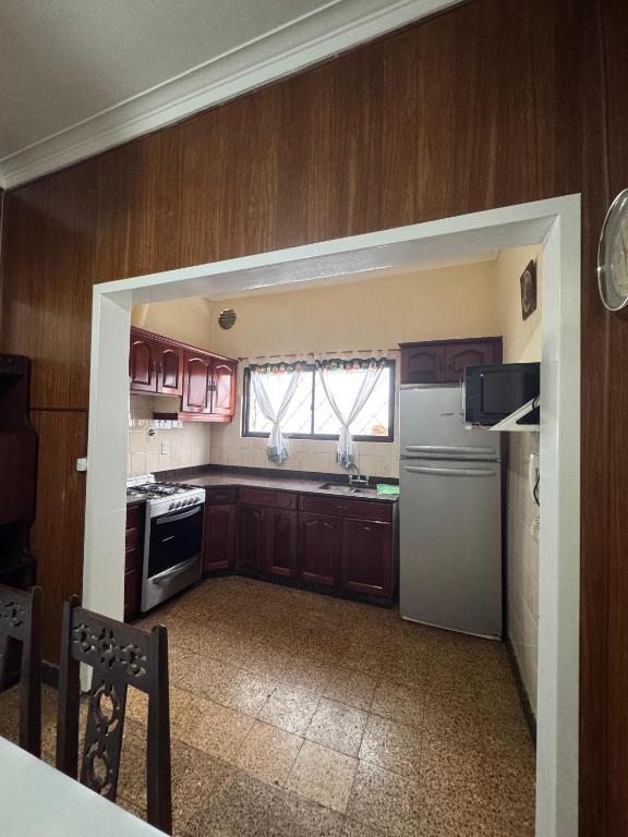 a kitchen with wooden cabinets and a white refrigerator at La Casa de la Nona Elisa in Mar del Plata