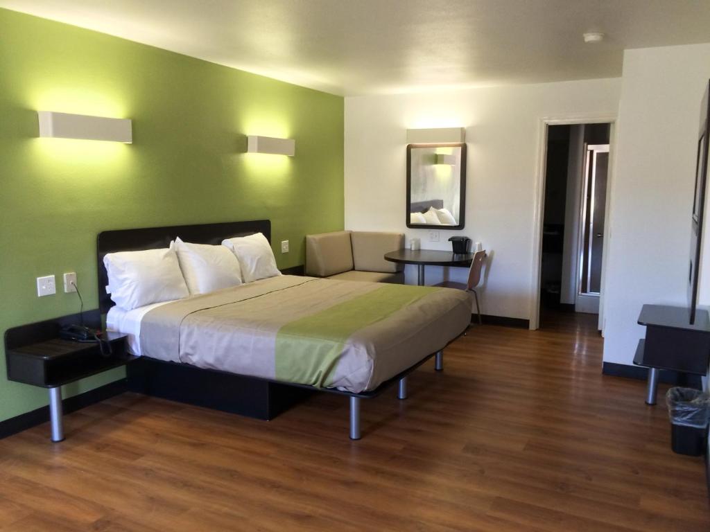 a bedroom with a bed and a green wall at Motel 6-Longview, TX - North in Longview