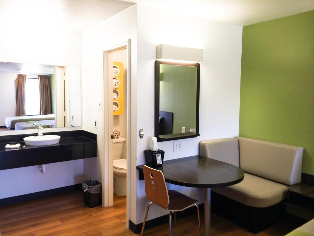 a bathroom with a table and a sink and a mirror at Motel 6-Longview, TX - North in Longview