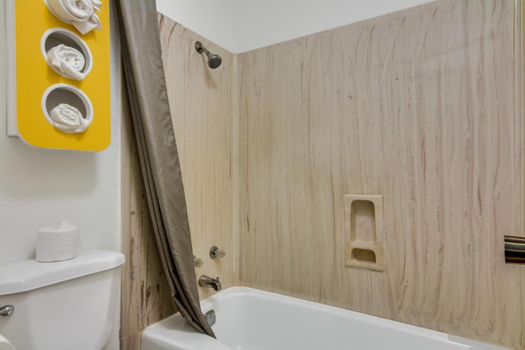 a bathroom with a white tub and a toilet at Motel 6-Longview, TX - North in Longview