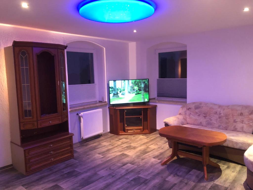 a living room with a couch and a flat screen tv at Ferienwohnung Ehrenfriedersdorf 18 in Ehrenfriedersdorf