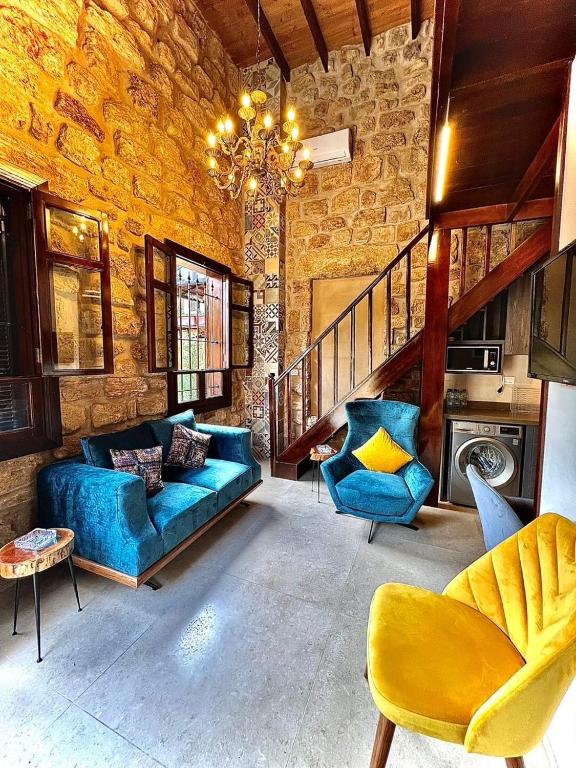 a living room with blue couches and a chandelier at Batroun Old Town private duplex with garden in Batroûn