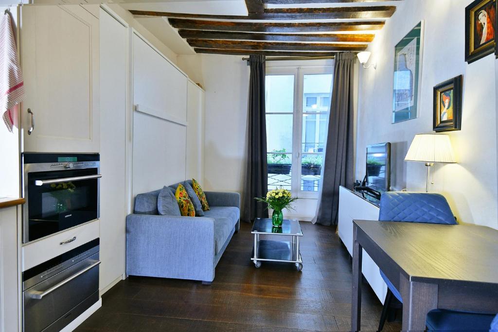 un salon avec un canapé et une télévision dans l'établissement Romantic studio in center of Paris, à Paris