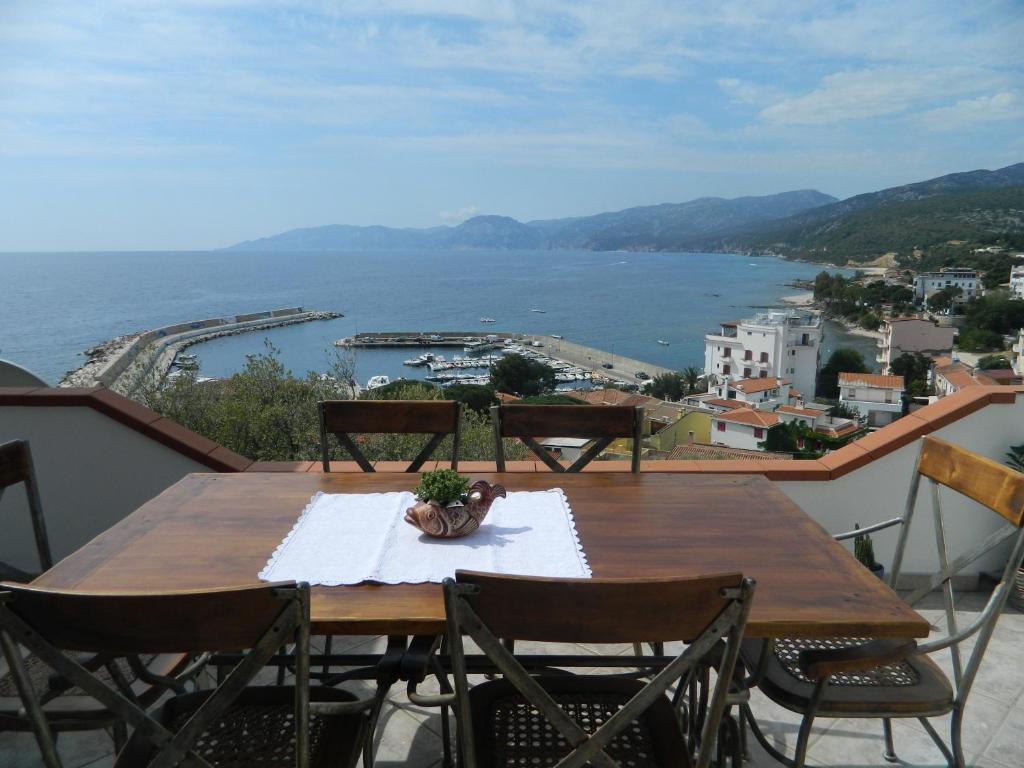 a table on a balcony with a view of the water at Appartamento 5 Vista Panoramica in Cala Gonone