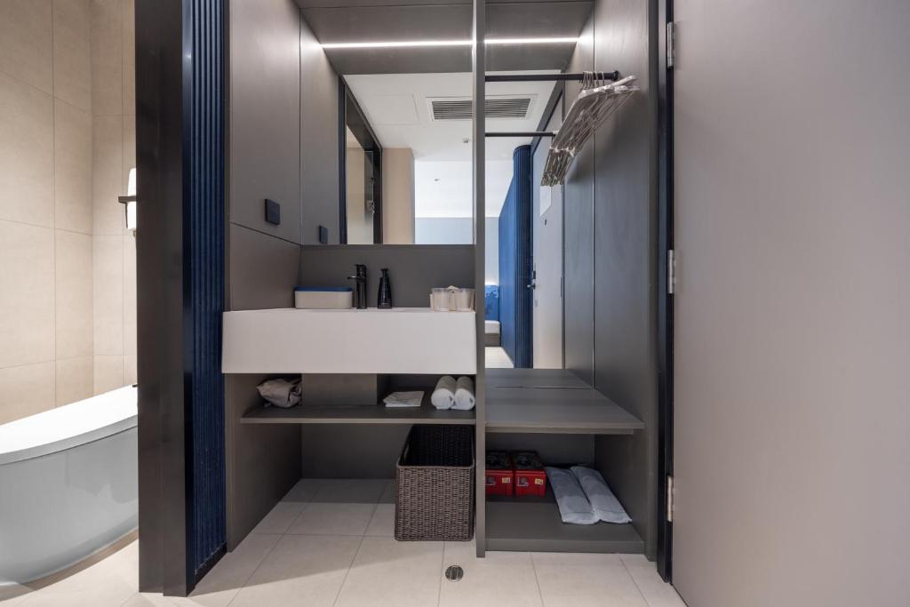 a bathroom with a white sink and a mirror at Atour Light Hotel Chengdu Yulin Street Nijia Bridge in Chengdu