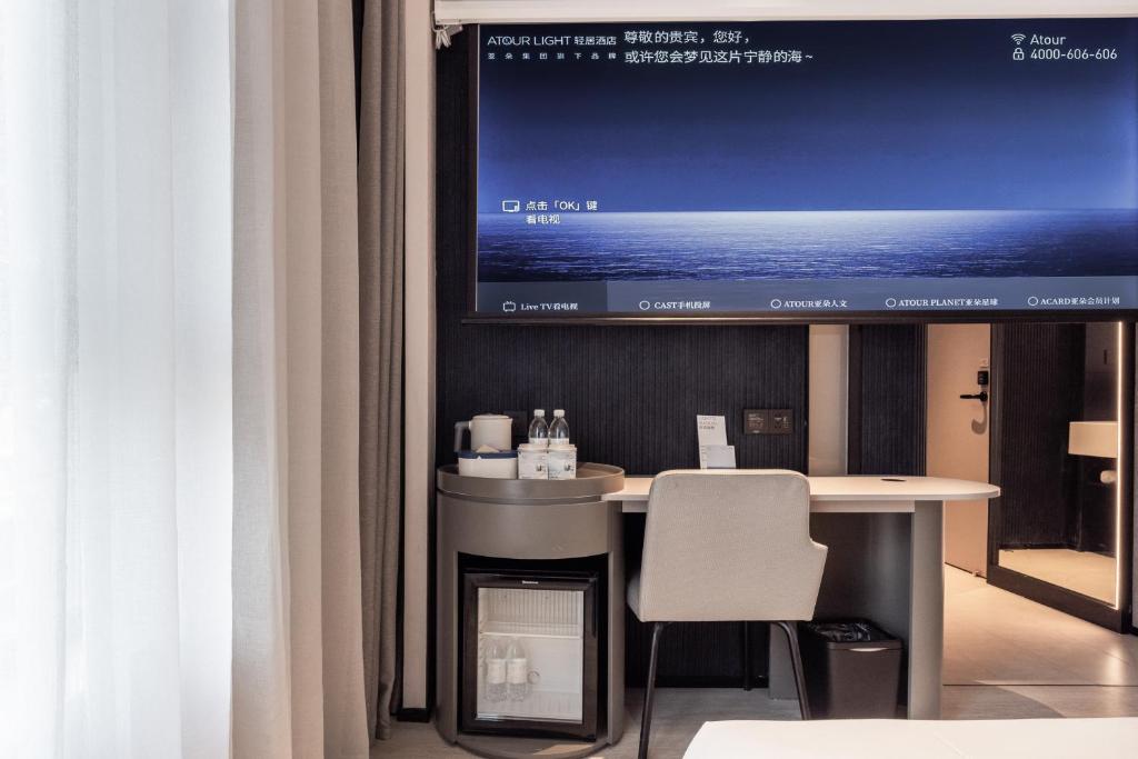 a desk with a tv in a room with curtains at Atour Light Hotel Chengdu Yulin Street Nijia Bridge in Chengdu